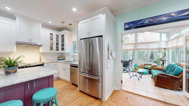 kitchen featuring white cabinets, glass insert cabinets, appliances with stainless steel finishes, under cabinet range hood, and a sink