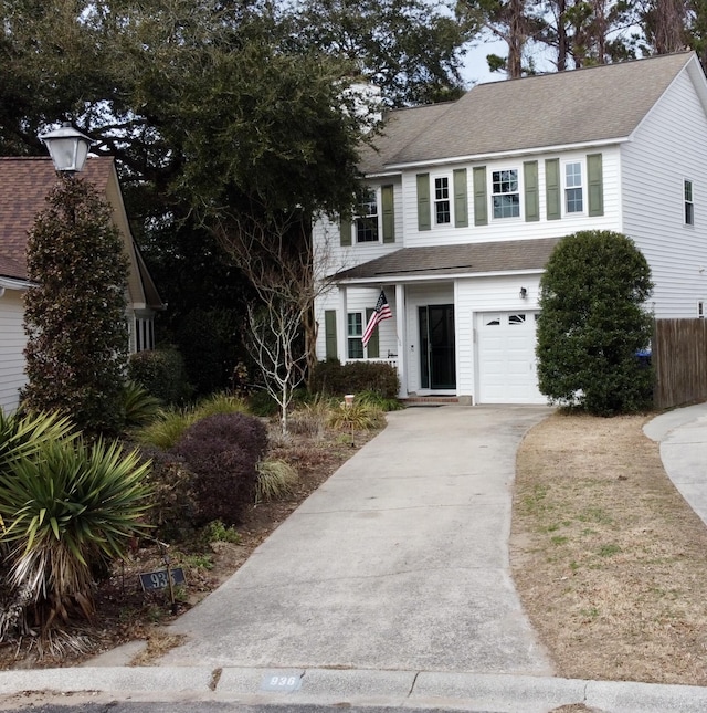 view of front of property with a garage, concrete driveway, roof with shingles, and fence