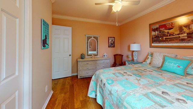 bedroom featuring a ceiling fan, crown molding, baseboards, and wood finished floors