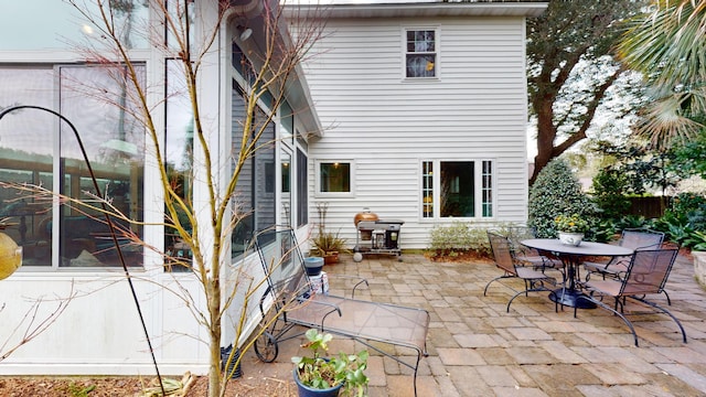 rear view of property featuring outdoor dining area and a patio