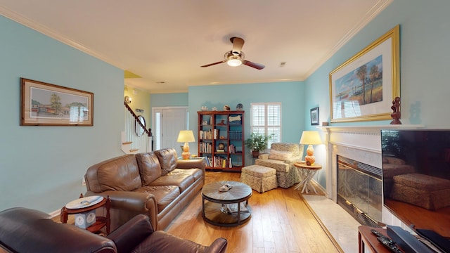 living area featuring stairs, a high end fireplace, hardwood / wood-style flooring, and crown molding