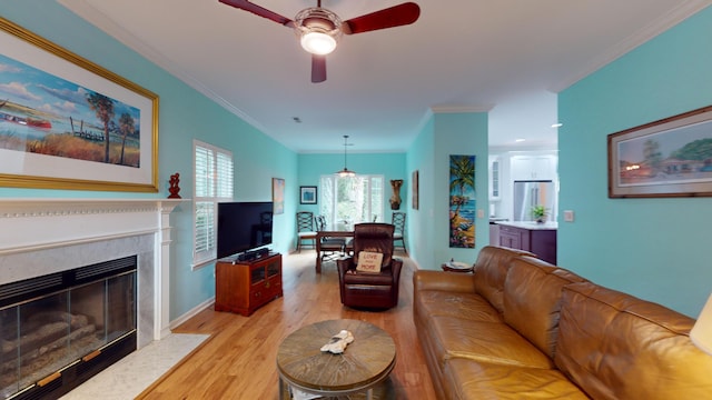 living room with a high end fireplace, light wood-type flooring, and crown molding