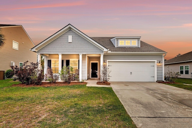 view of front of home with concrete driveway, a shingled roof, a porch, a yard, and a garage