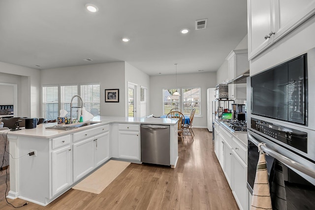 kitchen with light wood-type flooring, visible vents, stainless steel appliances, and a sink