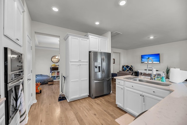 kitchen featuring recessed lighting, visible vents, a sink, appliances with stainless steel finishes, and white cabinetry