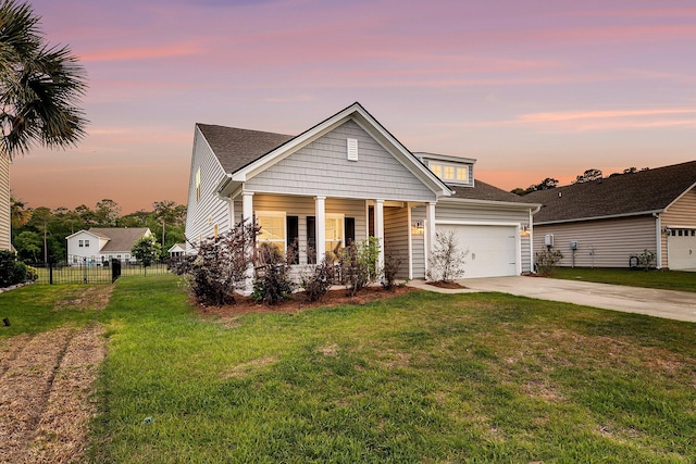 view of front of home featuring fence, a front lawn, an attached garage, driveway, and covered porch