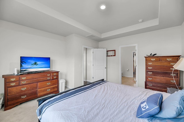carpeted bedroom with ensuite bath, visible vents, and baseboards