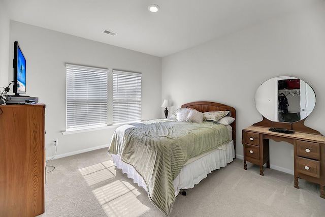 bedroom featuring baseboards, visible vents, and light colored carpet