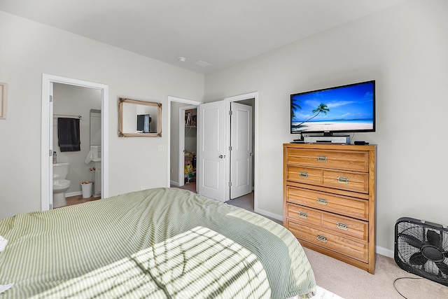 bedroom featuring ensuite bath, baseboards, and carpet