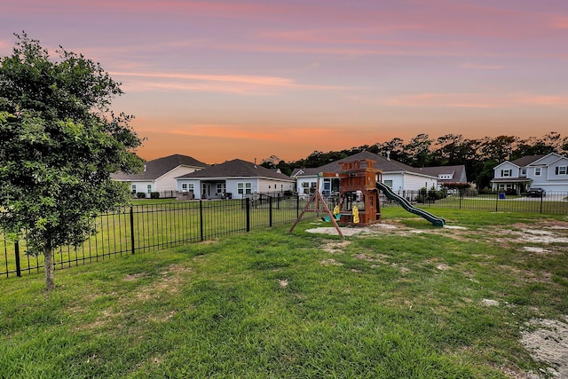 view of yard with a residential view, a fenced backyard, and a playground