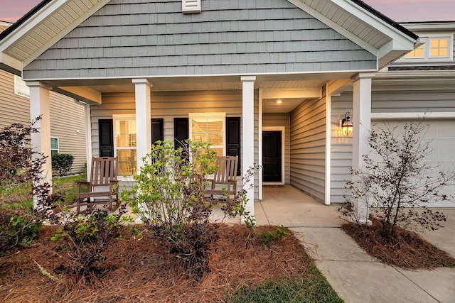 view of exterior entry featuring covered porch