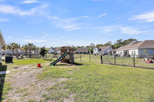 view of yard featuring fence, central AC unit, a residential view, and a playground