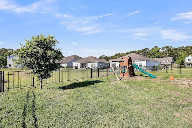 view of yard with a residential view, a fenced backyard, and a playground