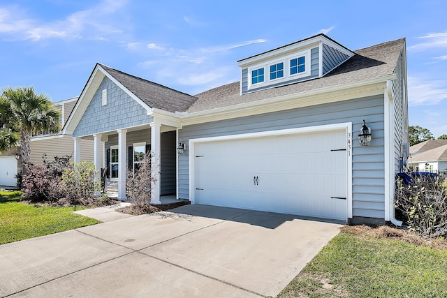 view of front of home with concrete driveway, a porch, a shingled roof, and a garage