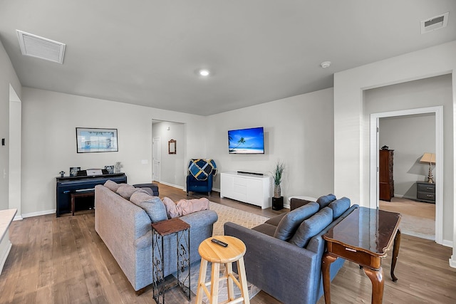 living room featuring baseboards, wood finished floors, and visible vents