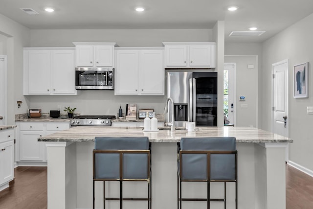 1132 Wading Point Blvd, Huger, SC 29450 - kitchen featuring appliances with stainless steel finishes, dark wood-style floors, white cabinets, a breakfast bar area, and recessed lighting