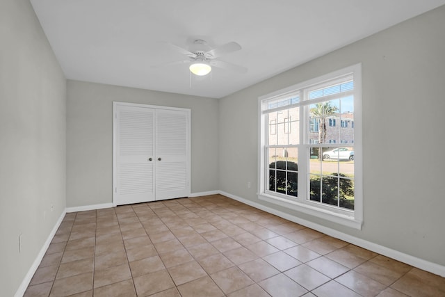 spare room featuring plenty of natural light, baseboards, and ceiling fan