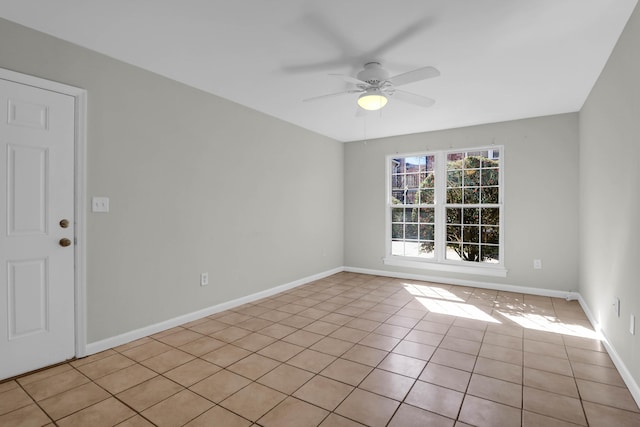 spare room featuring light tile patterned floors, ceiling fan, and baseboards