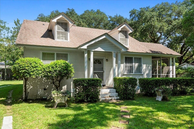 cape cod home with a front lawn