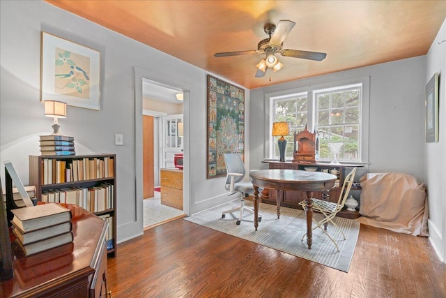 living area with hardwood / wood-style floors and ceiling fan