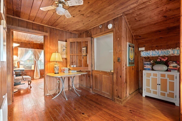 home office with wooden walls, hardwood / wood-style floors, ceiling fan, and wood ceiling