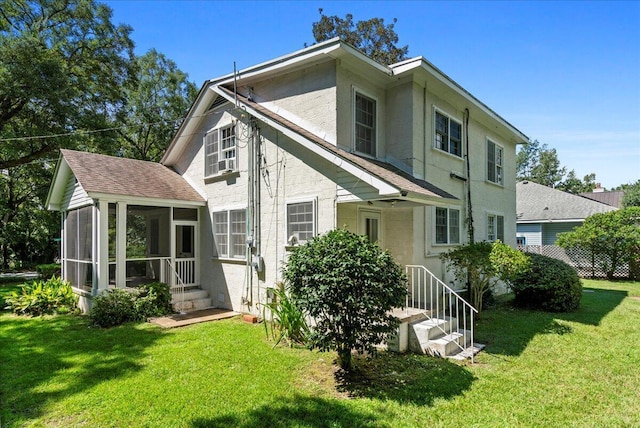 back of property featuring a sunroom and a lawn