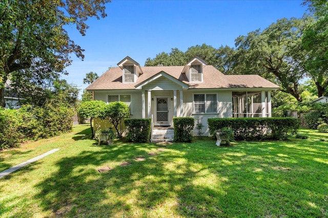 view of front facade with a sunroom and a front lawn