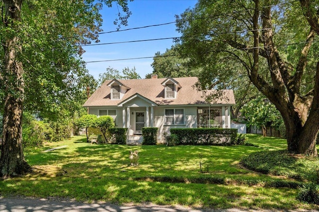 cape cod home featuring a front yard