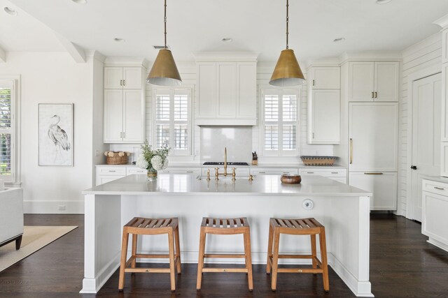 kitchen featuring appliances with stainless steel finishes, a kitchen island with sink, white cabinets, and dark hardwood / wood-style floors