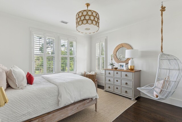 bedroom with dark hardwood / wood-style floors and ornamental molding