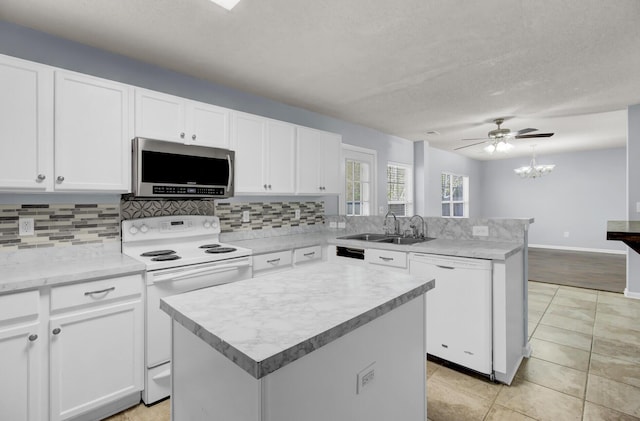 kitchen with sink, white appliances, a center island, and white cabinets