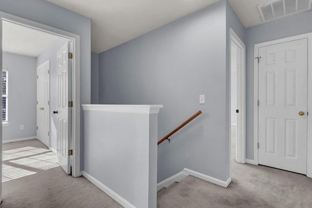 corridor featuring light colored carpet