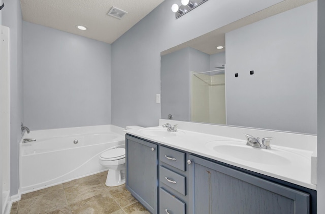 bathroom with a textured ceiling, toilet, a tub to relax in, and vanity