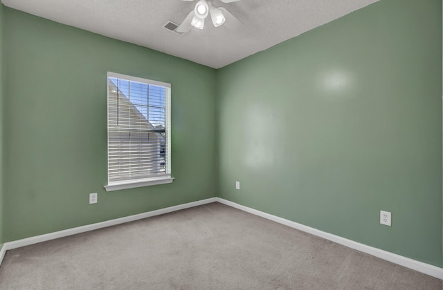 empty room with a textured ceiling, carpet floors, and ceiling fan