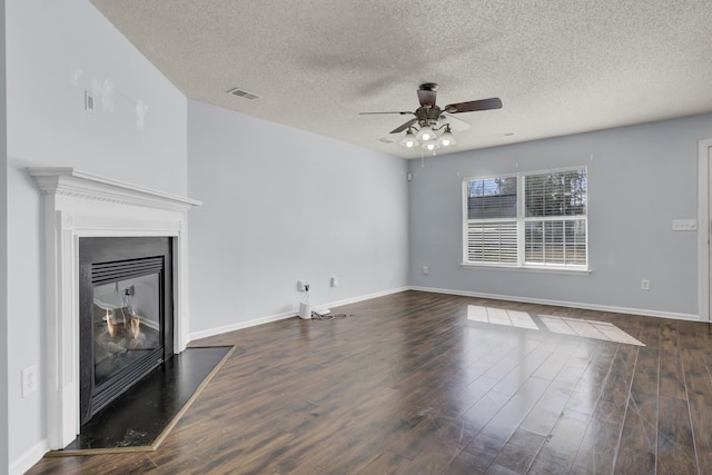 unfurnished living room with ceiling fan, a textured ceiling, and dark hardwood / wood-style floors