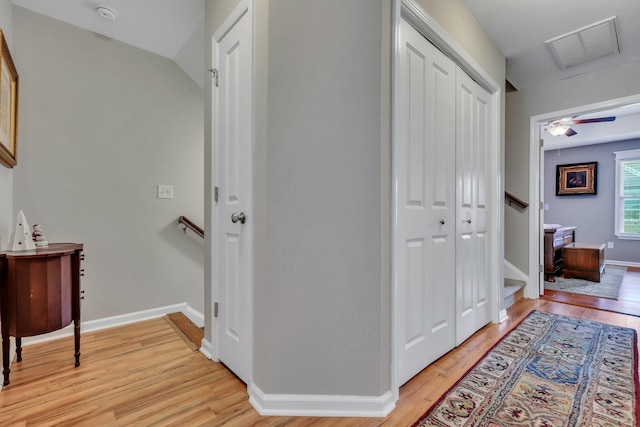 hallway featuring light hardwood / wood-style floors and vaulted ceiling