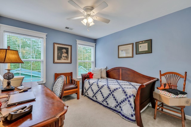 bedroom featuring access to exterior, ceiling fan, light colored carpet, and multiple windows