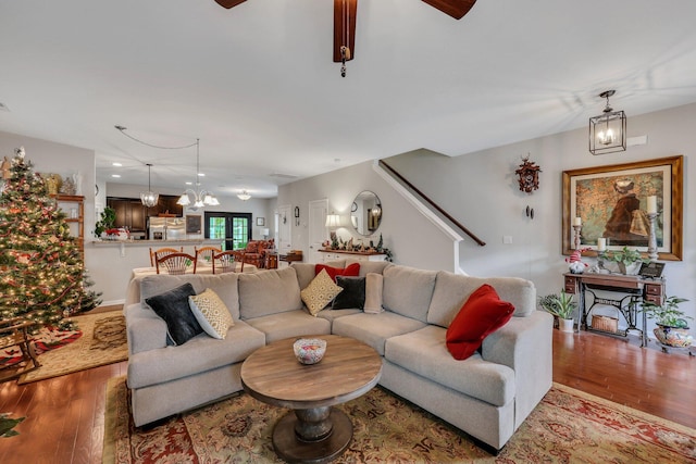 living room with hardwood / wood-style flooring and ceiling fan with notable chandelier