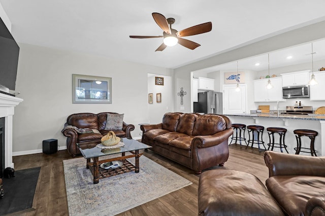 living room featuring ceiling fan and dark wood-type flooring