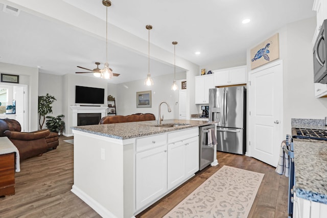 kitchen featuring white cabinets, sink, a center island with sink, appliances with stainless steel finishes, and dark hardwood / wood-style flooring