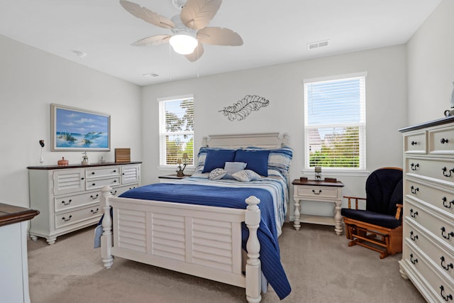 carpeted bedroom with multiple windows and ceiling fan