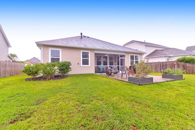 back of property with a sunroom, a yard, and a patio