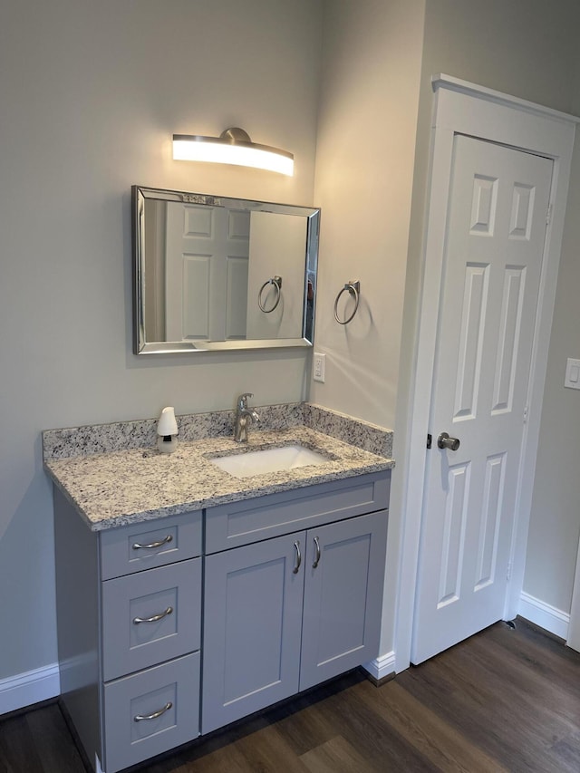 bathroom with wood finished floors, vanity, and baseboards