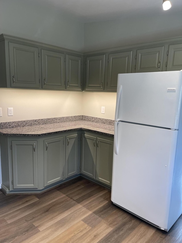 kitchen featuring light countertops, wood finished floors, and freestanding refrigerator