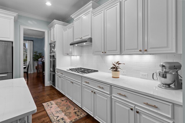 2792 River Vista Way, Mount Pleasant, SC 29466 - kitchen with stainless steel appliances, under cabinet range hood, crown molding, white cabinetry, and dark wood finished floors
