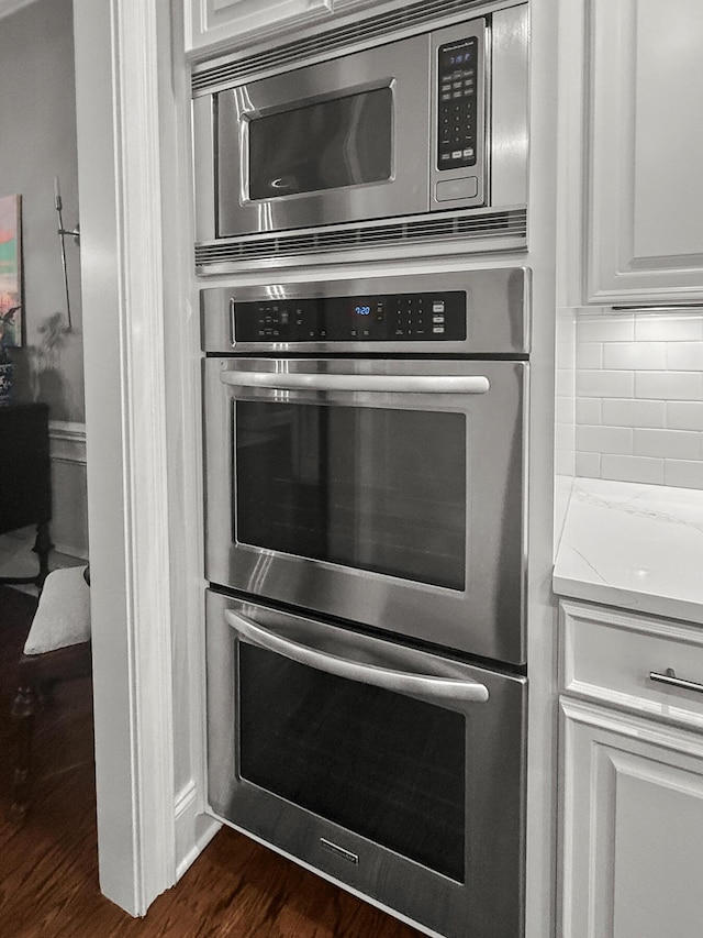 2792 River Vista Way, Mount Pleasant, SC 29466 - kitchen view of stainless steel appliances, dark wood-style flooring, backsplash, and white cabinetry