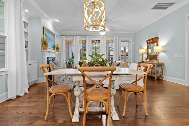 2792 River Vista Way, Mount Pleasant, SC 29466 - dining area featuring crown molding, a fireplace, baseboards, wood finished floors, and built in shelves