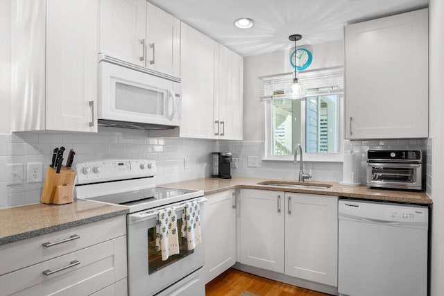 kitchen featuring sink, white cabinetry, pendant lighting, white appliances, and backsplash