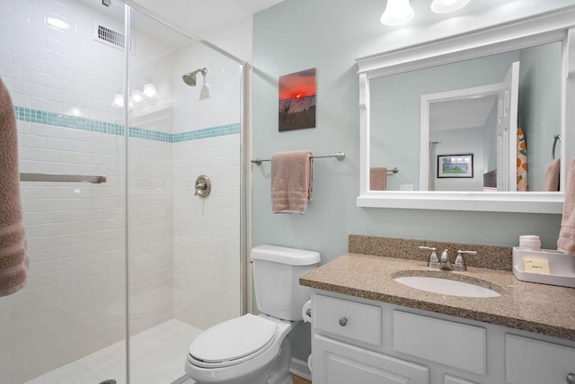 bathroom featuring vanity, toilet, and an enclosed shower