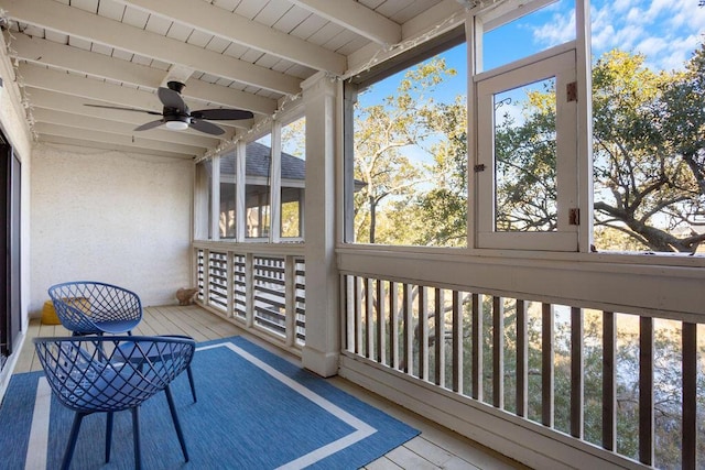 sunroom featuring ceiling fan, wooden ceiling, and beam ceiling